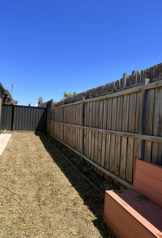 A long narrow side path along a timber fence cleared back to short grass